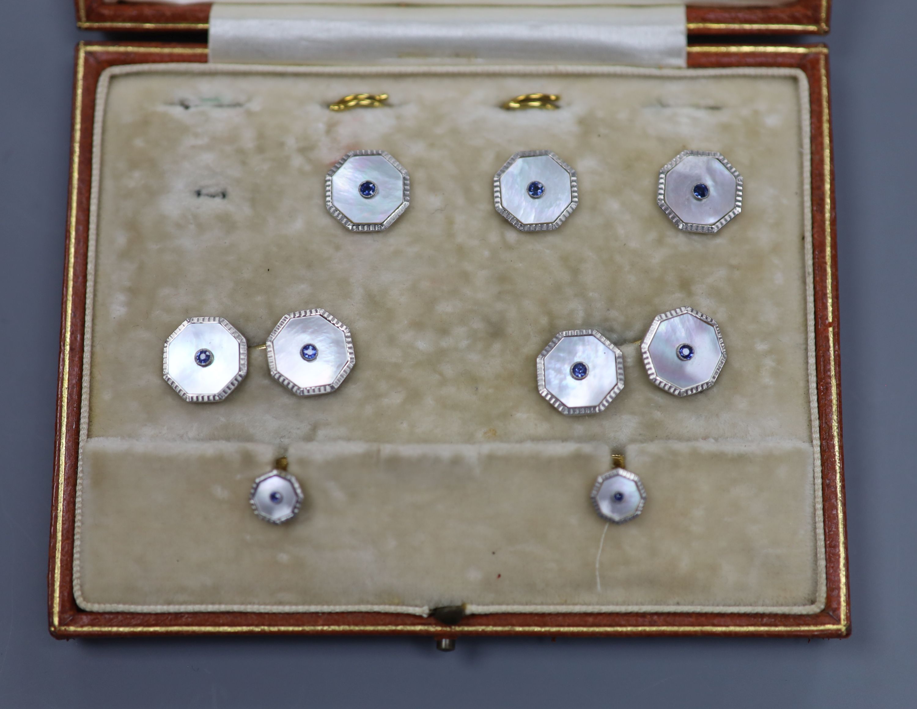 An early 20th century 18ct & Pt, mother of pearl and sapphire set octagonal part dress stud set (one stud missing)